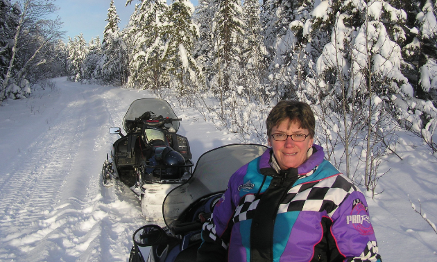 Rob Vipond’s wife, Shirley, sits on a snowmobile in The Pas, Manitoba.