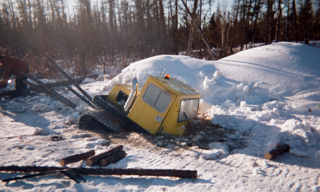 A Bombardier Bombi snow groomer is partially submerged in water.