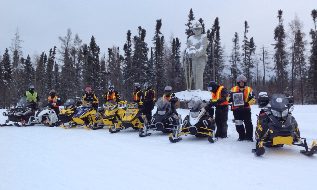 Thompson, Manitoba, where snowmobilers pose for a photo at the Journey for Sight Ride.