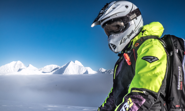 Jennifer Coulter poses for a photo on her snowmobile while in the mountains