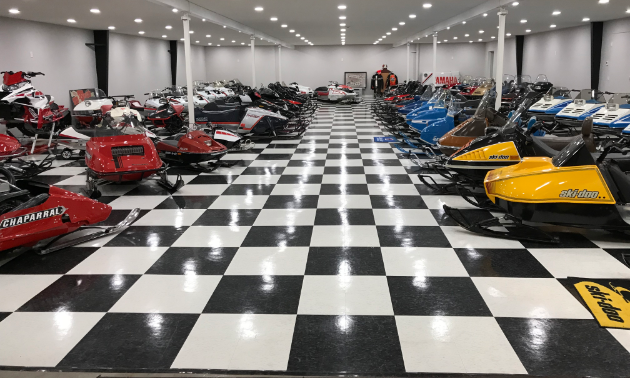 The first floor of Lorne’s Vintage Sleds boasts a bunch of snowmobiles and a shiny checkered floor.