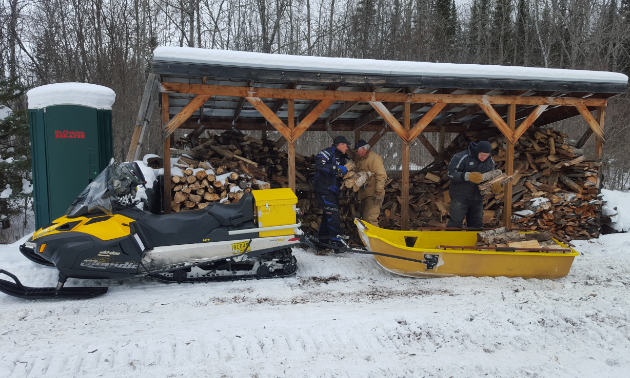 Volunteers with the Lee River Snow Riders load up and supply wood for five warm-up shelters.