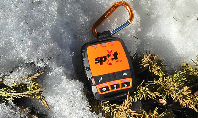 Orange and black Spot GPS device in the snow. 