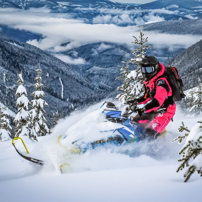 Gloria Cunningham rides through powder snow on her snowmobile.