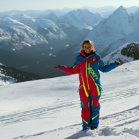 A young woman stands at the top of the mountains. 