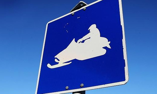 Blue sign with snowmobile graphic. 