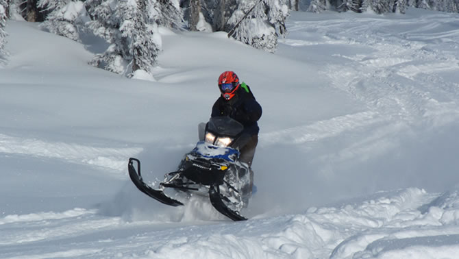 A snowmobiler carves up some deep powder in Blue River.