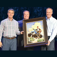 Three men presenting a boy scout picture