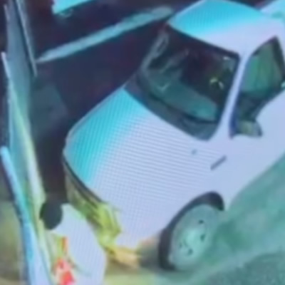 Screenshot of white truck and man breaking through gate. 