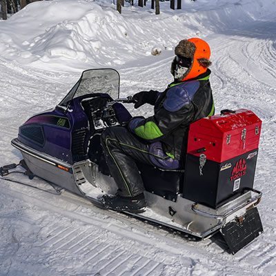 Kris Peltzer is shown here riding an old Arctic Cat 440 complete with custom Mac Tools tool box strapped on the back of his machine. 
