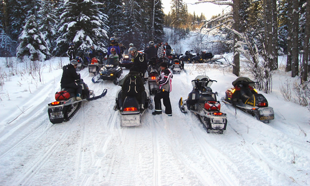 Snowmobilers stop for a break on the trail to Pepper Hill Cabin near Edson, Alberta, on the way to Silver Summit ski area.