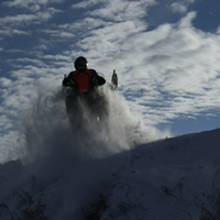 Erik catching some air on the Saskatoon Snowmobile Club's trails, while wearing a chest protector for safety.