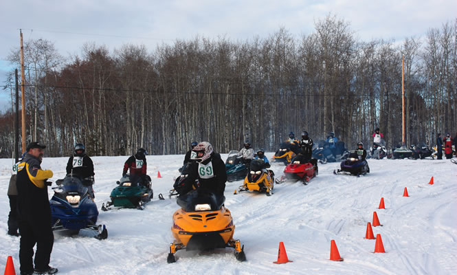 snowmobilers manoeuvring around orange cones