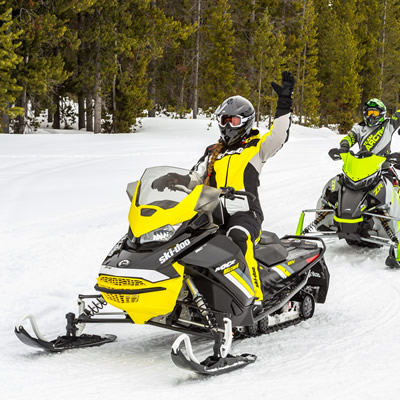 Group of snowmobilers out on a trail. 