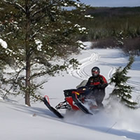 Marcel Dalpe shreds his Ski-Doo through a clearing near Hudson Bay, Saskatchewan.