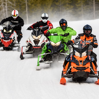 Group of snowmobilers on trail. 