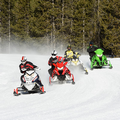Group of snowmobiles on trail. 
