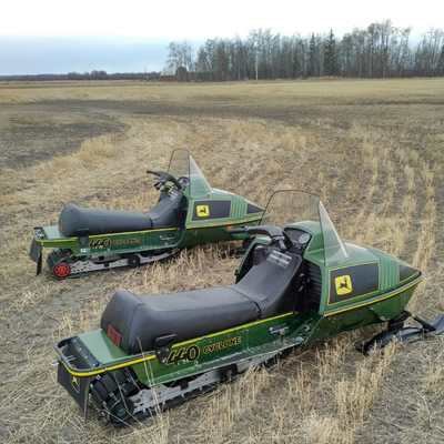 Two John Deere Cyclone sleds in a farmer's field. 