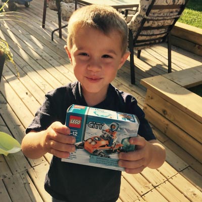 Picture of Grayson holding up package of LEGO.