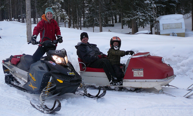 Family on vintage snowmobile