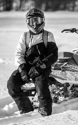 A black and white photo of Michael Fidek sitting on his sled