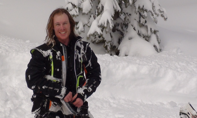 a snowmobiler posing with helmet off