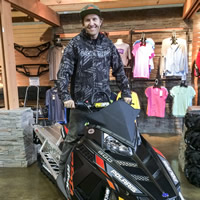 Chris Brown sitting on a Polaris snowmobile