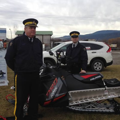 Two RCMP officers stand beside a bait sled. 