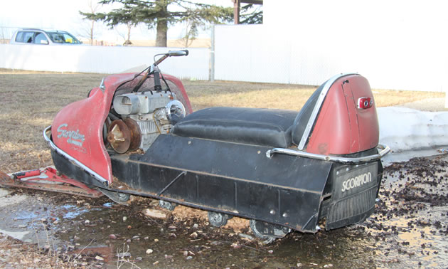 A red vintage Scorpion Trail-A-Sled snowmobile, view from rear. 