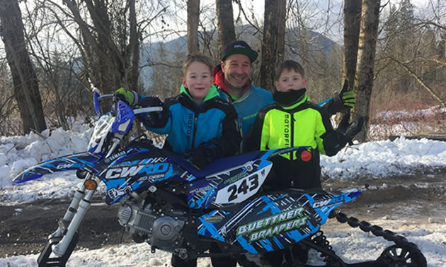 Man with two kids and snowbike. 