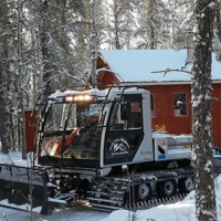 The club groomer in front of one of the new solar heated shelters along a scenic trail.