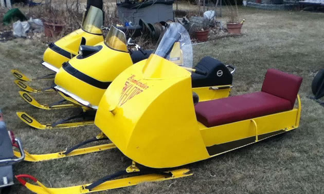 Line-up of yellow snowmobiles. 