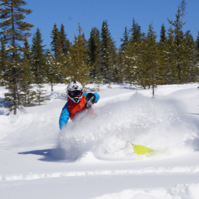 Eric Dargis is riding his snowmobile in powder.