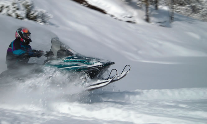 a snowmobiler punching through powdery snow