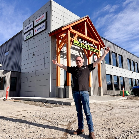 Owner of All Seasons Motor Sports in front of the building