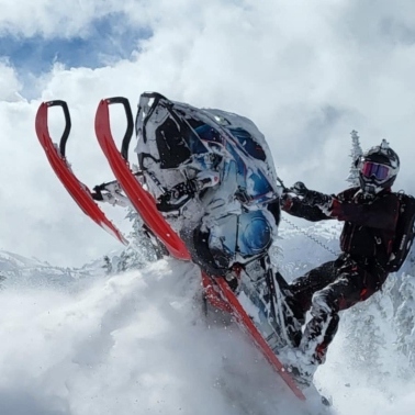 Brandon Shaw riding a snowmobile over a jump