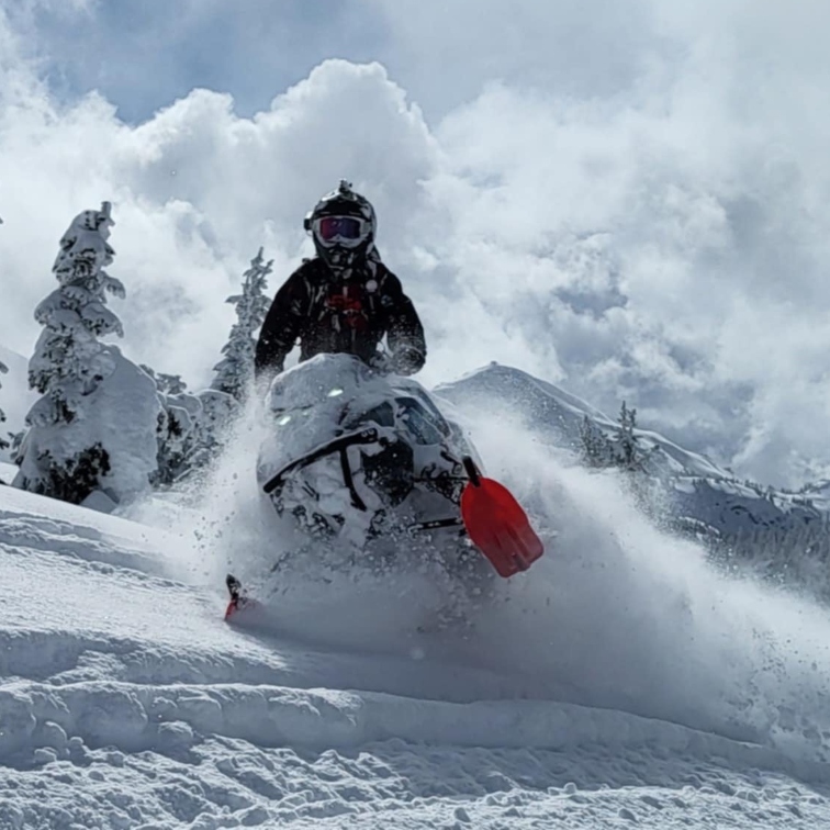 Brandon cruising through powder on a sled