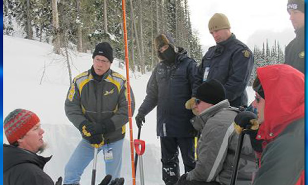 Brent Strand, (left) explains avalanche safety to a group of RCMP officers in 2011