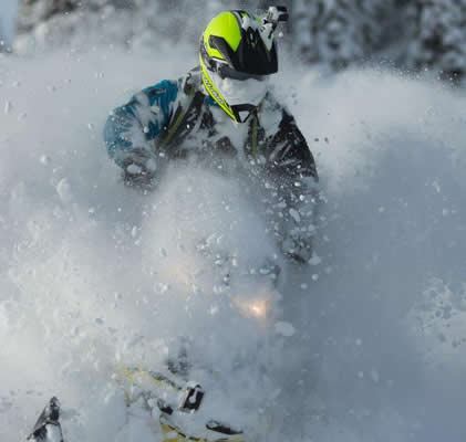 A sledder with a face and sled full of snow. 