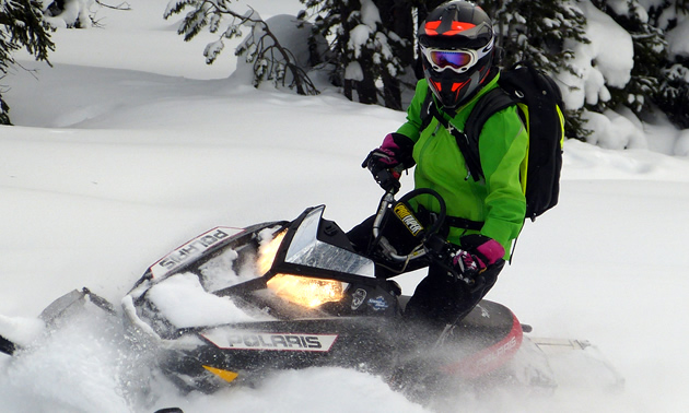Woman wearing Contessa Jacket on a black sled. 