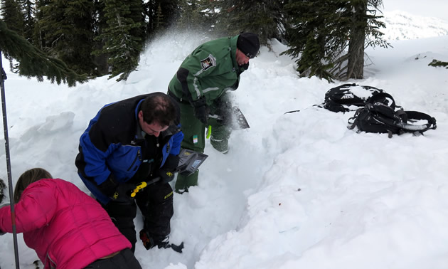 A group of AST students shoveling. 