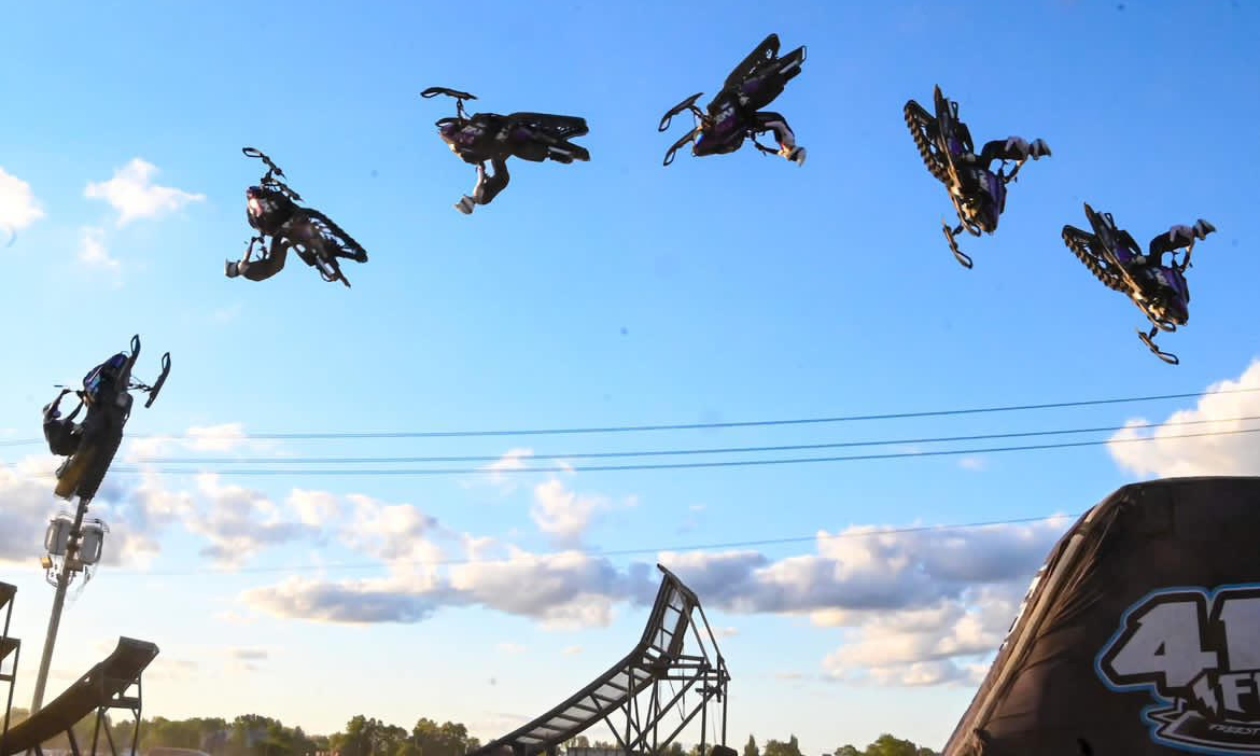 Chris riding his sled in a flip over a jump