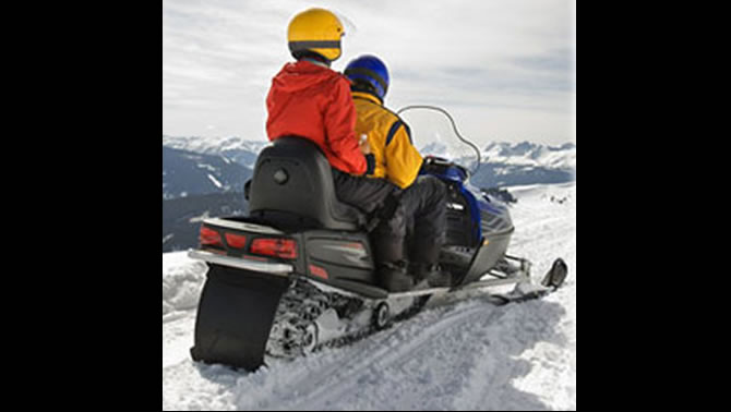 Couple riding on a snowmobile.