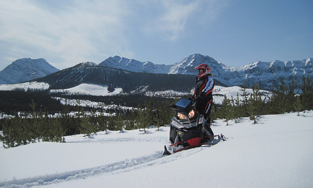Jennifer Dewar-Jones on her sled overlooking a valley in the Crowsnest Pass.