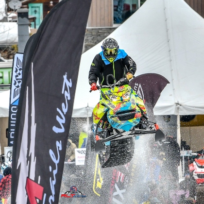 Daine riding a sled over a jump at an event