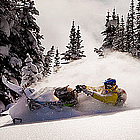 person snowmobiling in powdery snow