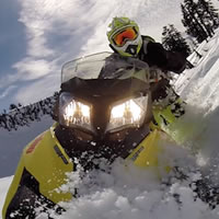 A GoPro photo looking back at a yellow Summit T3 sled and Dave Norona. 