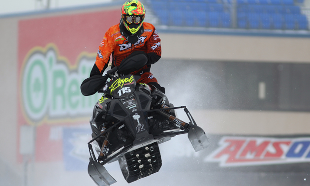 David Joanis snocross racer flies through the air in a race. 