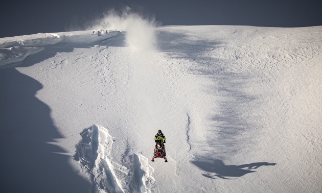 A sledder coming down a snowy slope