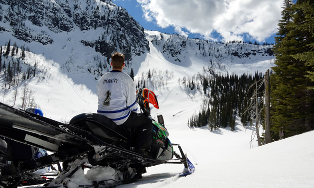 Chris Doratty on his sled looking up at a chute. 